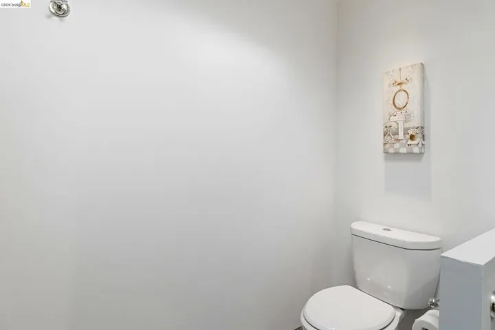 White toilet fixture with chrome flush handle and white tank lid