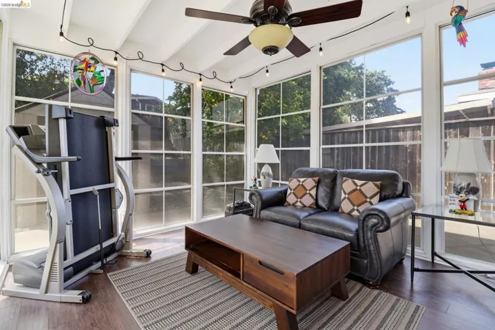 Sunroom with wood-finish flooring and a vaulted ceiling with exposed beams