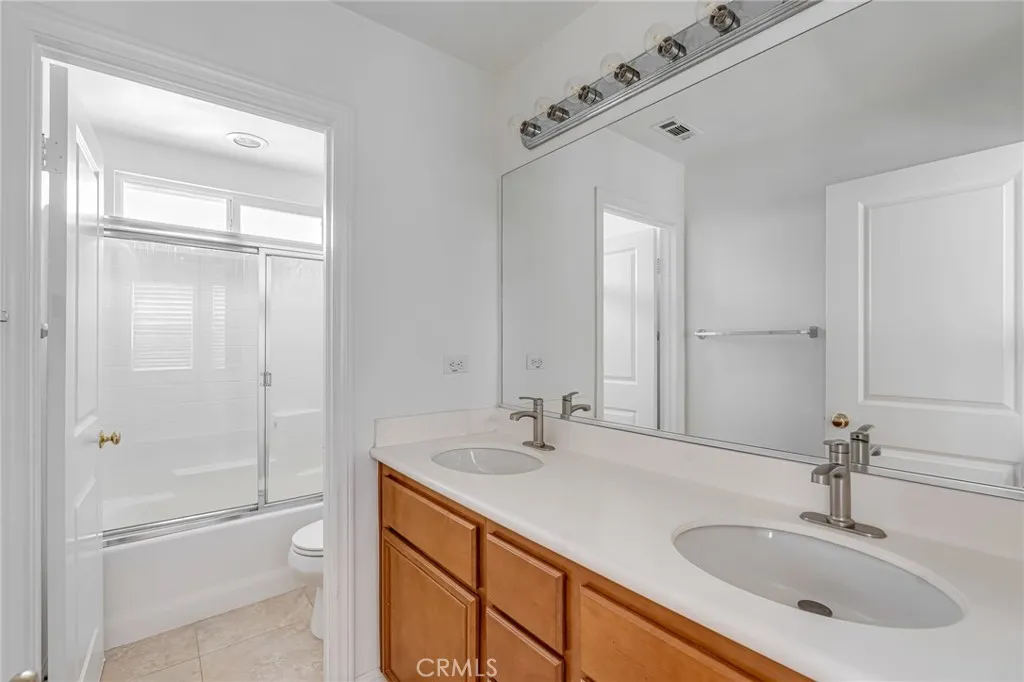 Hall full bathroom with double vanities, with separate door section door