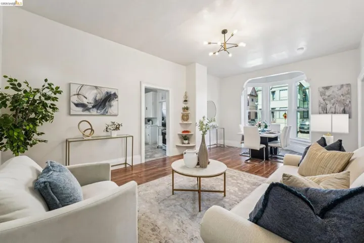 Living room featuring a chandelier, wood finished floors, and arched walkways