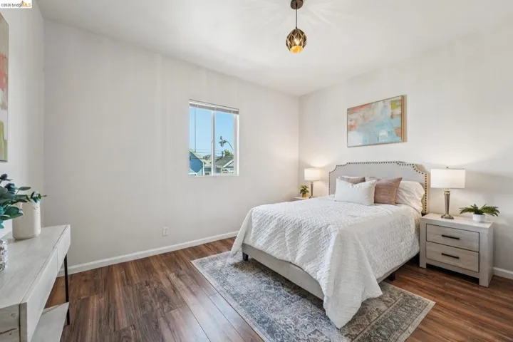 Bedroom featuring dark wood-style flooring and baseboards