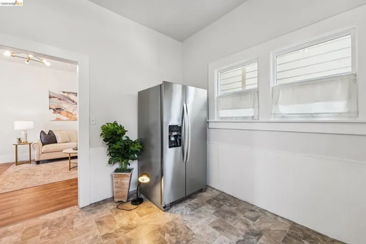 Kitchen featuring stainless steel fridge with ice dispenser and stone finish flooring