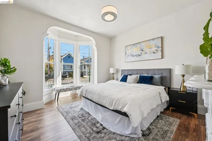 Bedroom with dark wood-style floors and baseboards