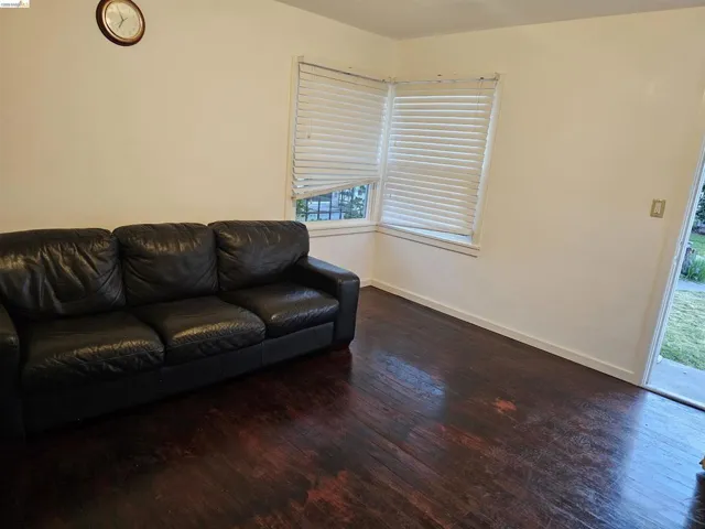 Hardwood-style flooring extends throughout this room, complemented by white walls and trim