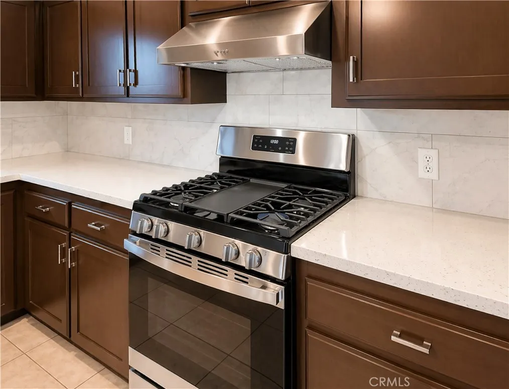 Kitchen with new Quartz countertop, backsplash, new gas stove and hood
