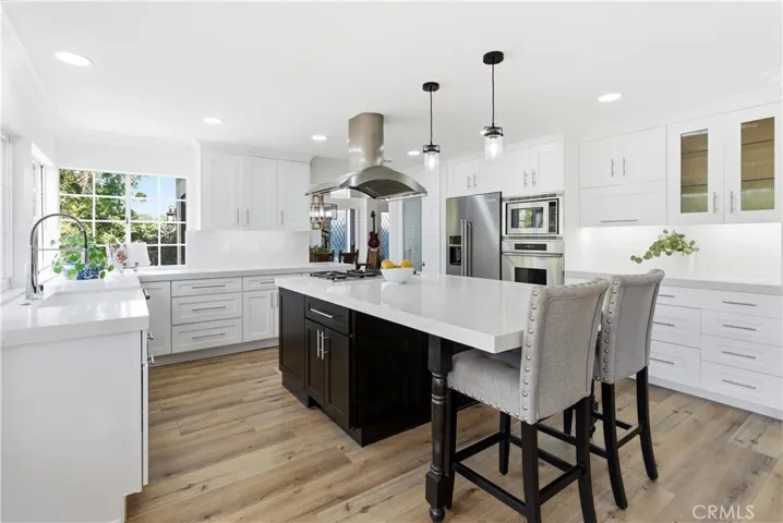 Beautifully updated kitchen featuring a spacious island, stainless steel appliances, and open-concept living.