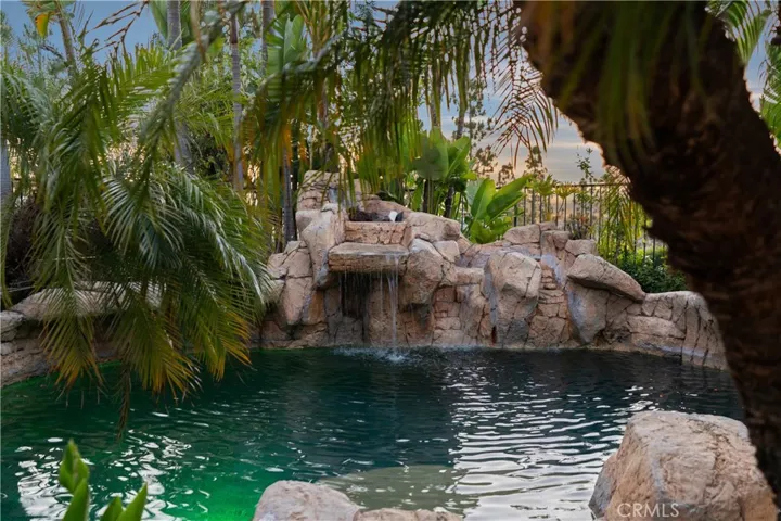 Private backyard retreat featuring a custom rock pool, spa, and cascading waterfalls.