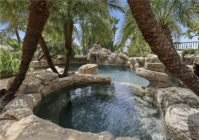 Private backyard retreat featuring a custom rock pool, spa, and cascading waterfalls.