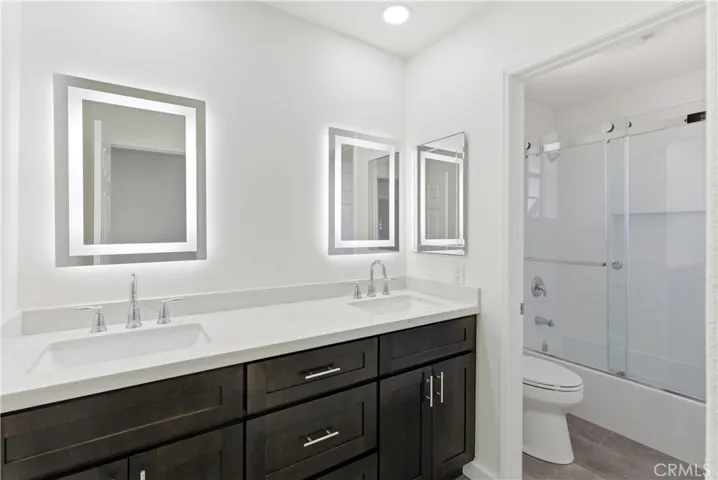 Updated bathroom with dual sinks and a shower/tub combination.