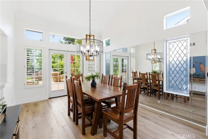 Light-filled dining area with soaring ceilings, expansive windows, and seamless indoor-outdoor flow.
