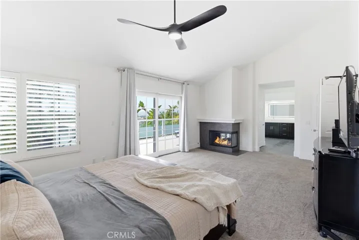 Light-filled primary suite with a fireplace, generous layout, and direct access to a private deck.