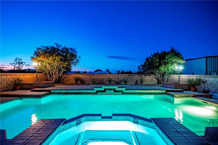 twilight view of the pool and spa