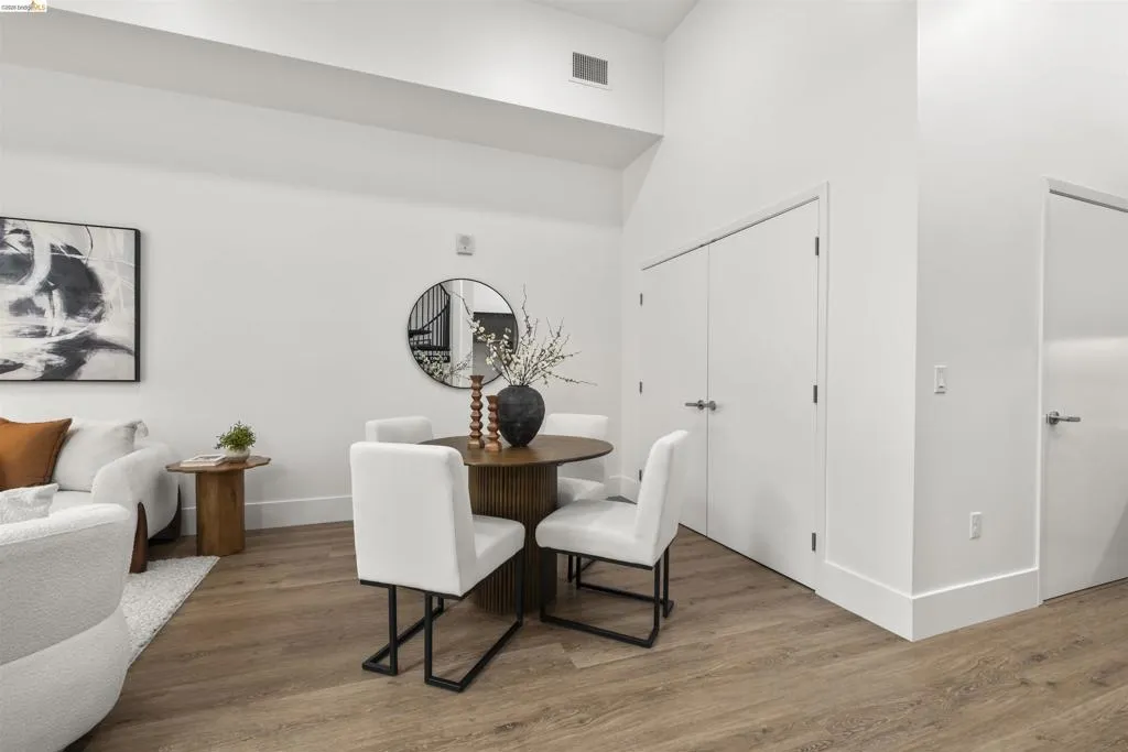 Dining area with wood finished floors and a high ceiling