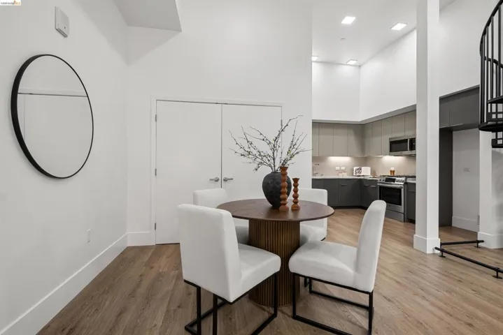 Dining area featuring a towering ceiling and light wood-style flooring