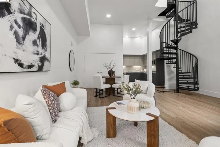 Living room with a high ceiling, wood finished floors, and stairway