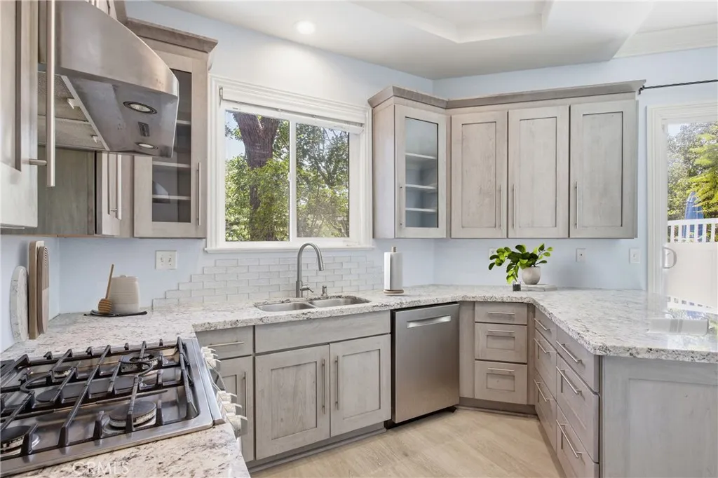 Remodeled kitchen with custom cabinetry, recessed lighting, and SS appliances.  Virtually staged.