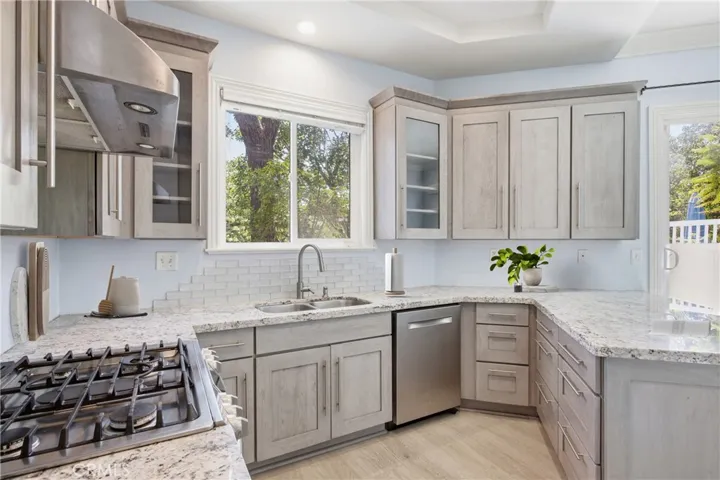 Remodeled kitchen with custom cabinetry, recessed lighting, and SS appliances.  Virtually staged.