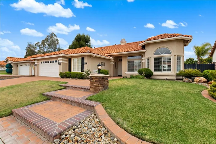 Beautifully Landscaped Single-Story Home With Paver Walkway, Stackstone Accents, And Inviting Curb Appeal