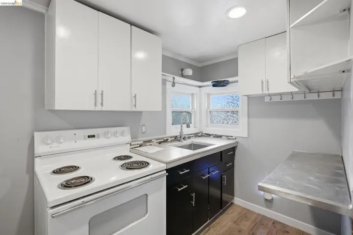 Compact kitchen with white upper cabinetry and dark lower cabinetry