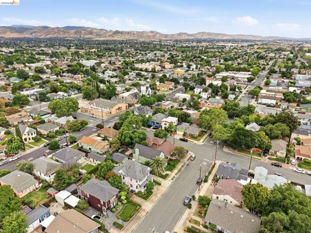 Residential neighborhood with mature trees and a distant mountain range