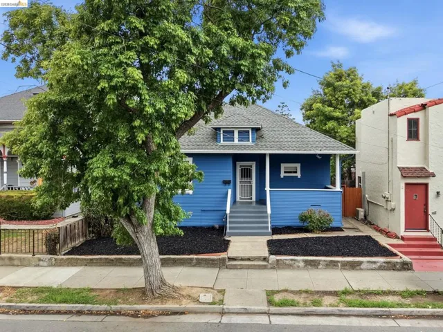 Blue exterior with white trim, featuring a covered front porch and gray painted steps