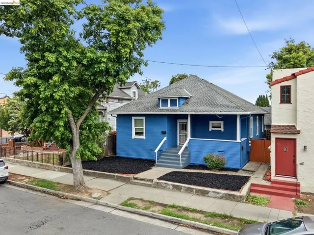 Blue exterior with white trim, featuring a gabled roof and a dormer window
