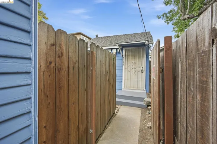 Wooden privacy fencing enclosing a narrow exterior pathway