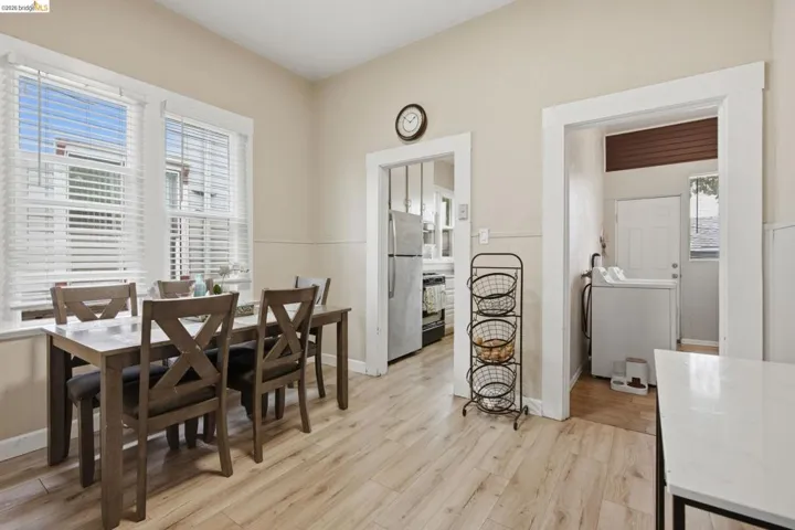 Dining area featuring wood-finish flooring, two large windows with blinds, and neutral wall paint