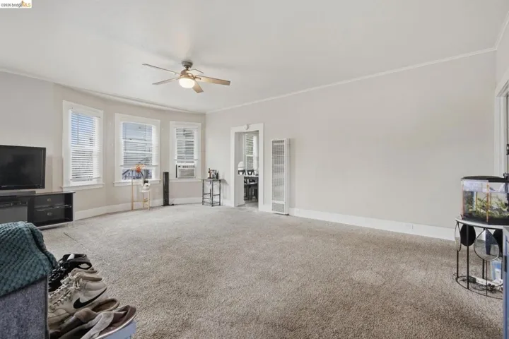 Spacious room featuring light-colored carpeting and white baseboards