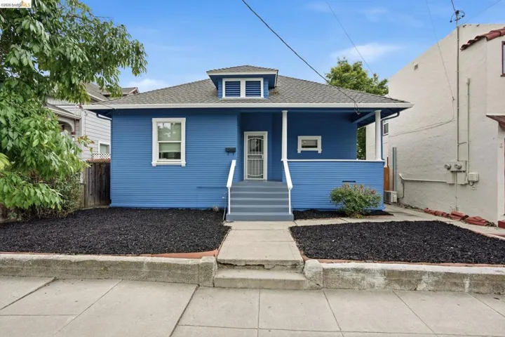 Blue siding exterior with white trim accents and a dormer window