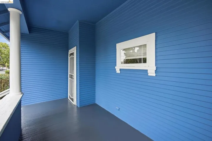 Covered porch featuring blue horizontal siding and a complementary grey floor