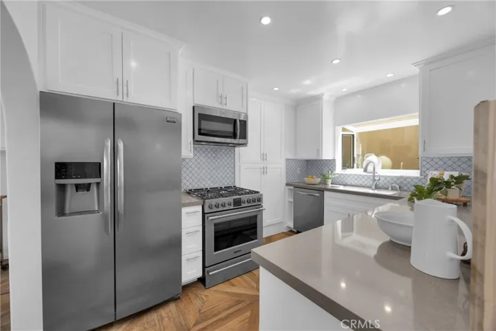Updated kitchen with stainless steel appliances, large pantry with pull outs and Cambria quartz countertops