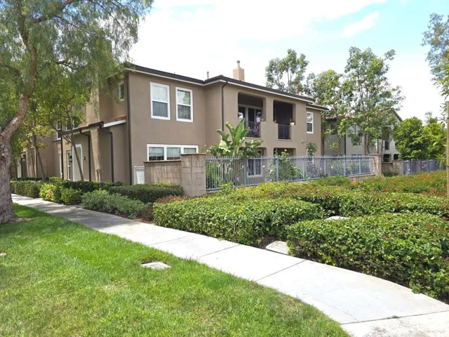 Showing the side yard patio with iron fence with the view of greenery.