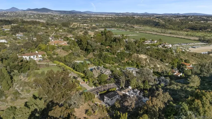 Privately nestled among rolling hills and lush natural surroundings, the estate enjoys a rare sense of seclusion with sweeping views that extend toward the renowned Del Mar Polo Grounds in the distance.