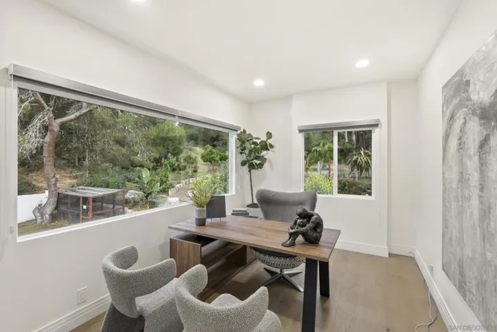 A bright private office overlooking lush natural surroundings, thoughtfully designed to inspire productivity with expansive windows, clean contemporary finishes, and a calm, elevated atmosphere.