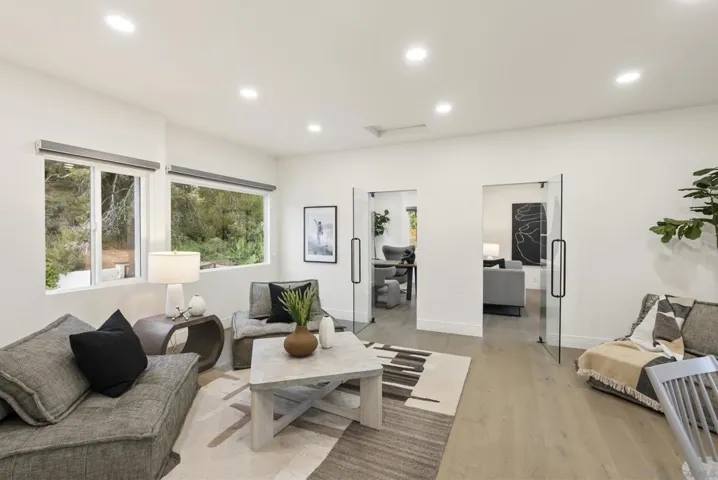 A versatile bonus retreat above the garage featuring two private office spaces, expansive windows, and flexible living areas designed for remote work, creative pursuits, or elevated guest accommodations.