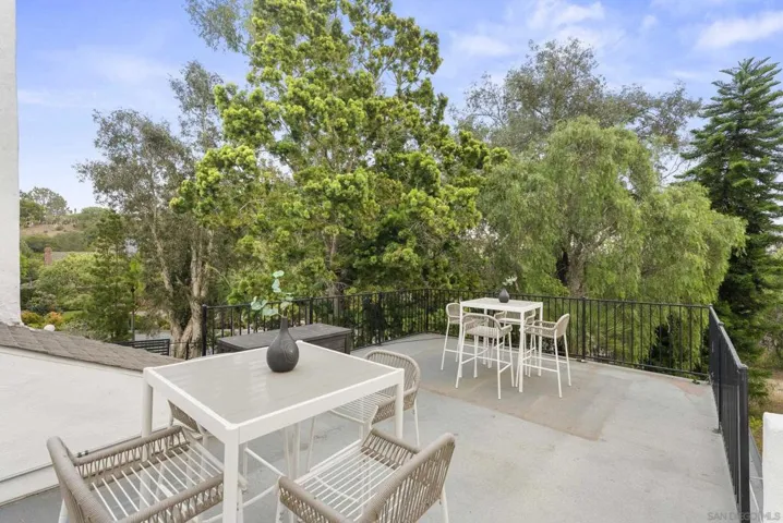 An elevated terrace just off the pool offers a peaceful setting for morning coffee or sunset cocktails, surrounded by mature trees and lush natural views that enhance the estate’s private resort-like atmosphere.