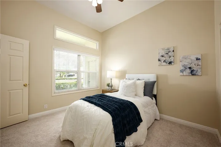 The guest bedroom features new carpet, a ceiling fan, and closet built-ins.