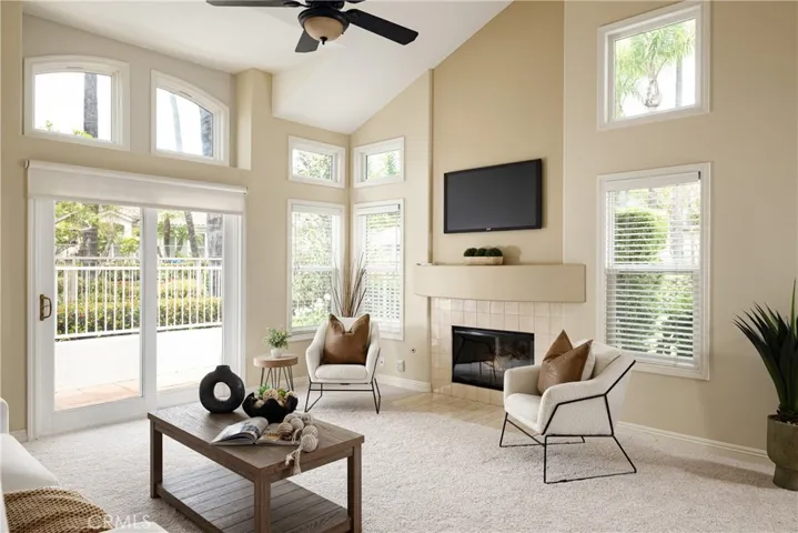 The spacious living room includes new carpet, a vaulted ceiling and a cozy fireplace.
