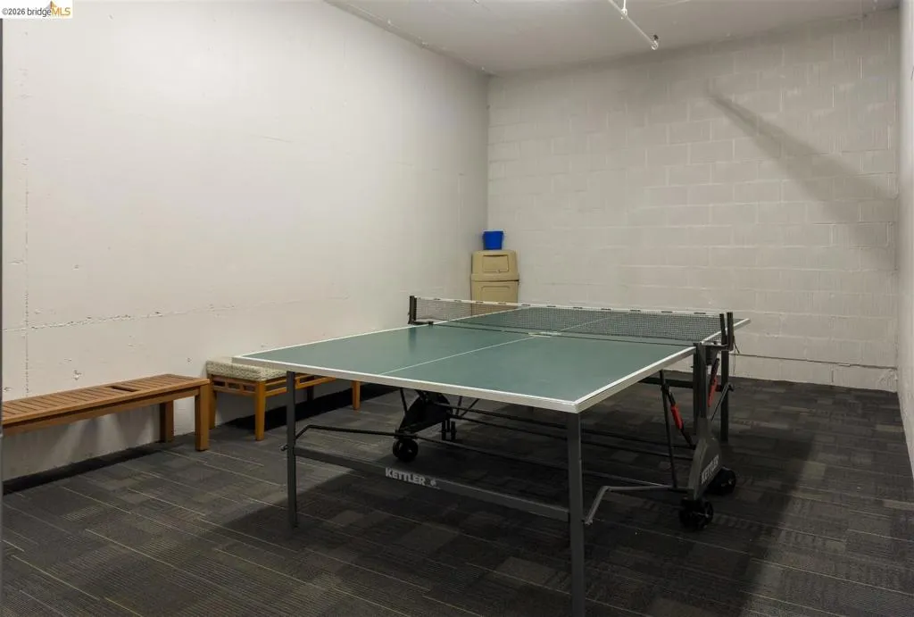 Recreation space featuring a ping-pong table and gray carpet tile flooring