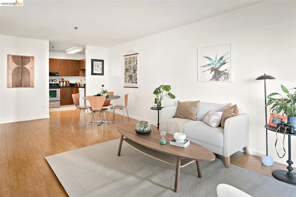 Open-concept living area featuring wood-finish flooring, white wall finishes, and recessed lighting