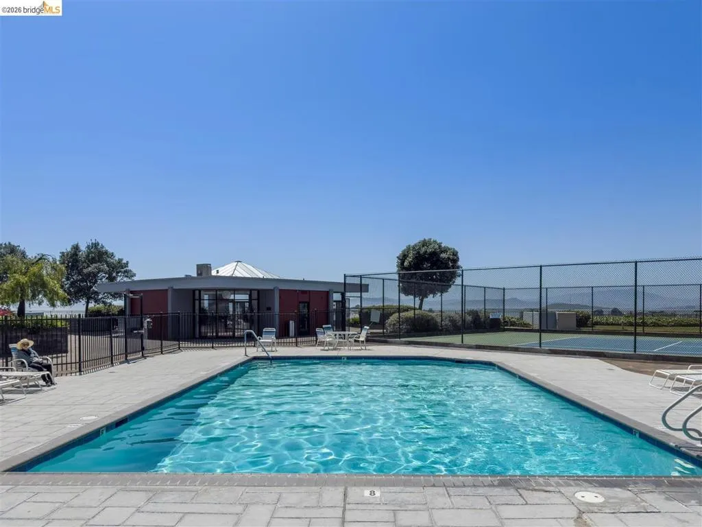 Rectangular swimming pool surrounded by a paved deck