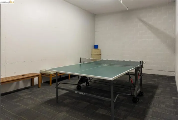Recreation space featuring a ping-pong table and gray carpet tile flooring