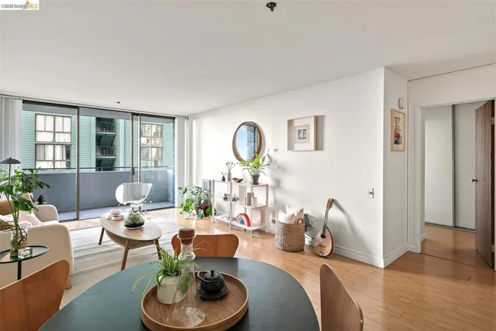 Open concept living area featuring wood-finish flooring, a full-height glass sliding door, and a private​​‌​​​​‌​​‌‌​​‌​​​‌‌​​​‌​​‌‌​​‌‌​​‌‌​​​​ balcony