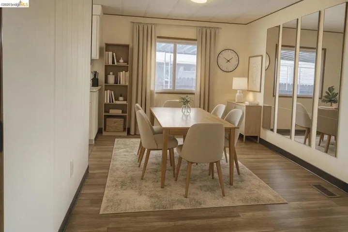 Dining space with dark wood-style flooring and baseboards