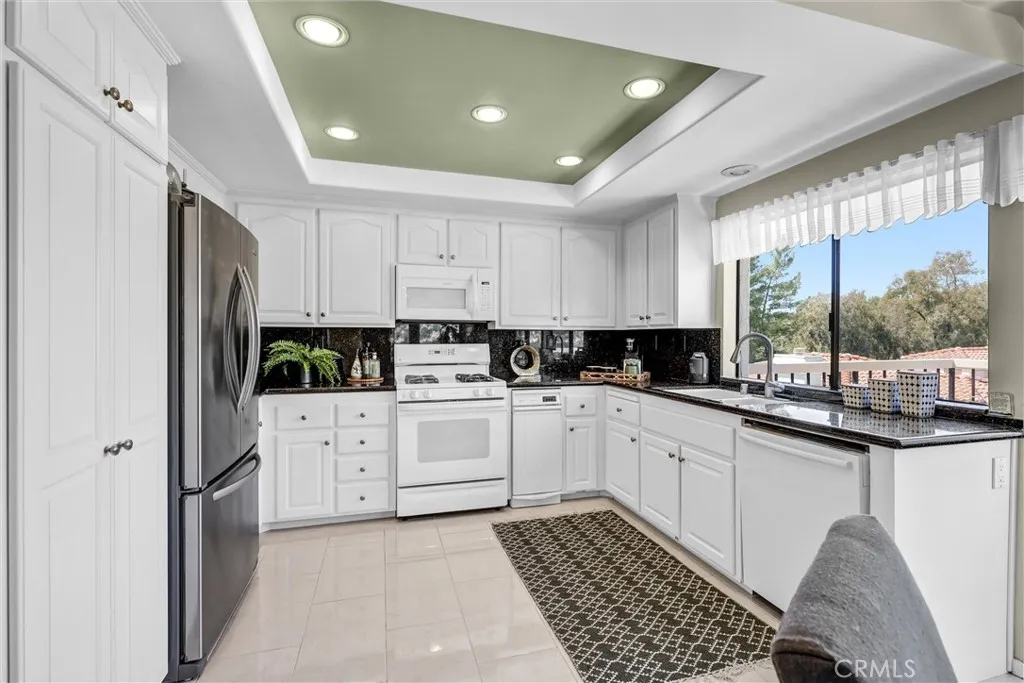 Spacious kitchen with black granite countertop and backsplash