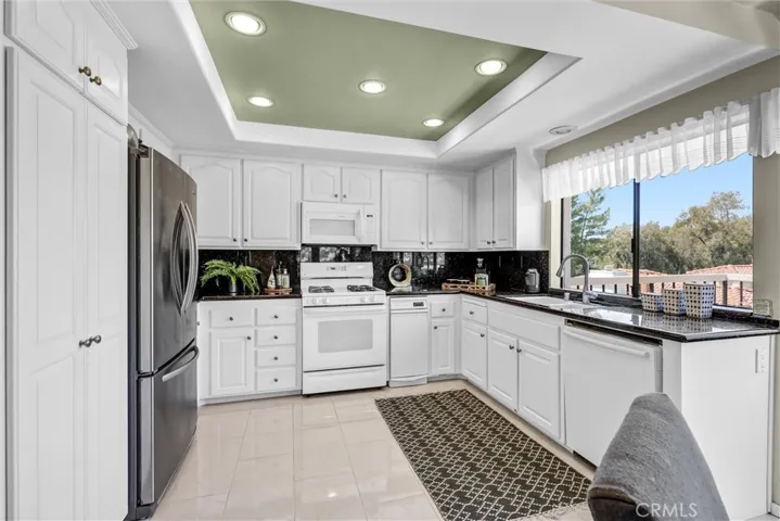 Spacious kitchen with black granite countertop and backsplash