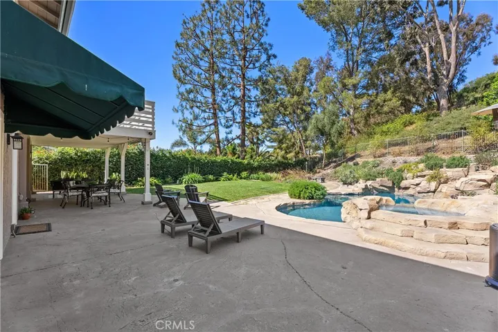 Oversized & private back patio overlooking pool, yard & slopes in the backyard.