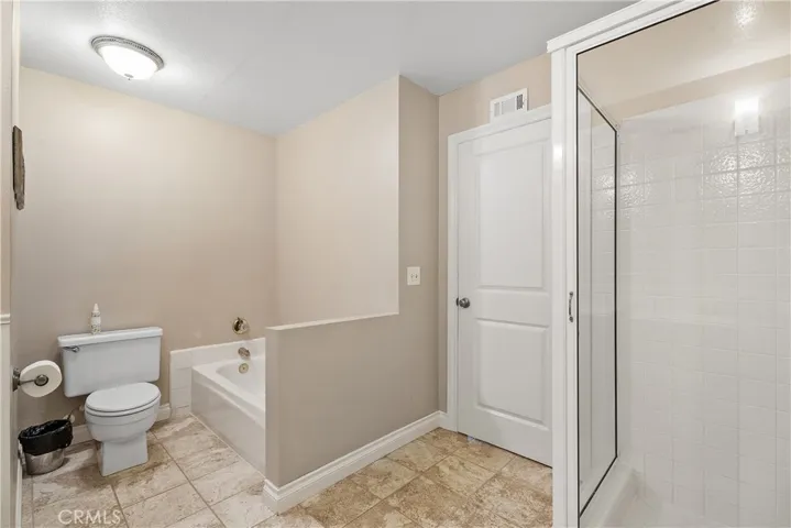 Full bathroom off upstairs hallway with shower, tub & double sinks with storage.