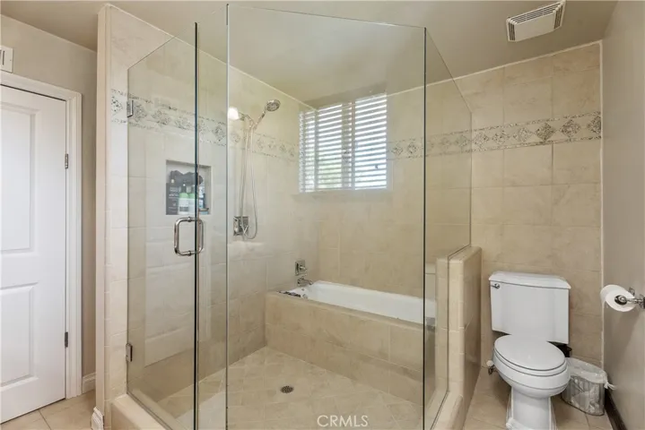 Primary bathroom with shower, tub and double sinks with storage.